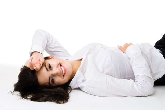 Happy young woman in white clothes lay on the floor