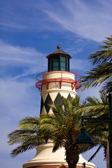beautiful lighthouse over blue sky and palm trees