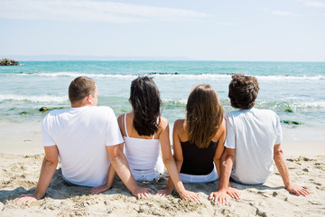 Rear view of a friends sitting on beach
