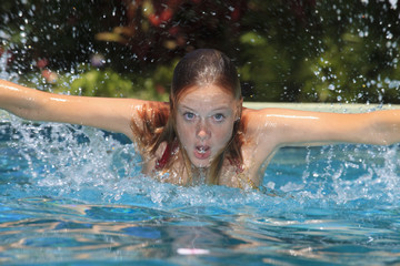 young woman swimming butterfly in a pool