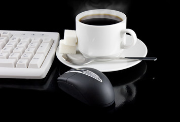 Cup of coffee, part of keyboard,mouse,on a black background