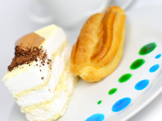Sponge cakes and custard cake on plate with fruit spots.Isolated