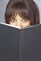 Young woman behind a big book
