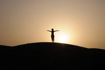 donna in relax nel deserto al tramonto