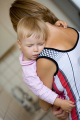 Child sleeps on the shoulder of his mother