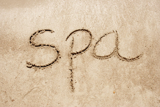Spa handwritten in sand on a beach