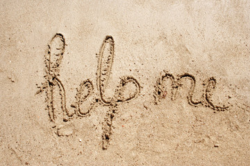 Help handwritten in sand on a beach