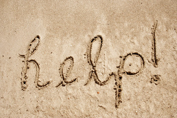 Help handwritten in sand on a beach