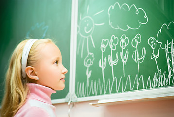 little girl drawing on school board