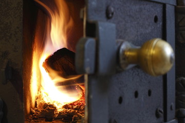 Fuoco che brucia all'interno di stufa a legna. Stufa tradizionale con tronchi sul fuoco,...
