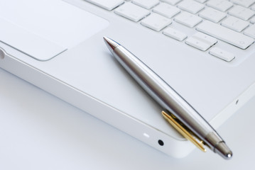 Silver pen on a laptop keyboard
