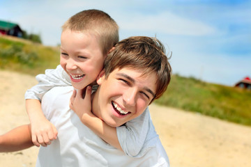 Fototapeta premium happy teenager and kid on the beach