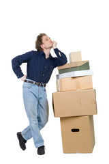 young man standing near pile of boxes leaned his elbow on it