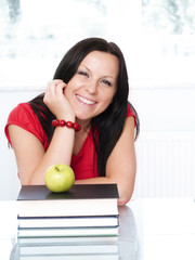 smiling brunette student woman with books and apple