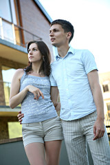 Naklejka premium Couple in front of house in modern residential area.