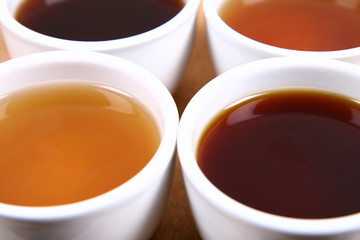 Four white bowls of  green, red, black and white tea