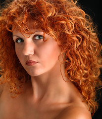 Fototapeta premium Portrait of beautiful redhead woman with rich curly hair