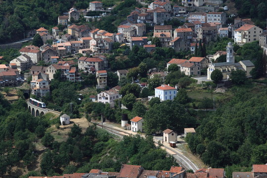 Mountain village in Corsica with a train going over a viaduct
