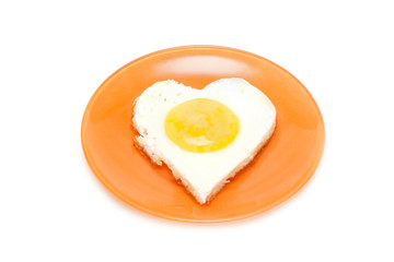 Fried egg in form heart on plate