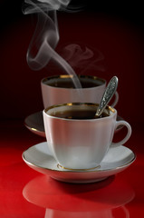 Two cups of coffee on a red-black background