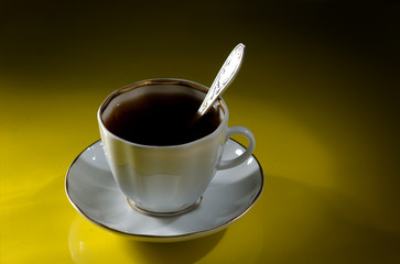 White cup of coffee on a yellow-black background