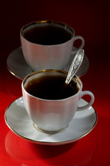 Two cups of coffee on a red-black background