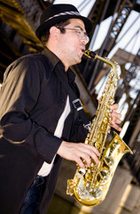 Obraz na płótnie Canvas saxophonist plays outdoors at sunset