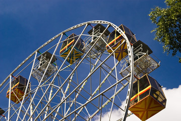 Attraction is the Ferris wheel on background blue sky