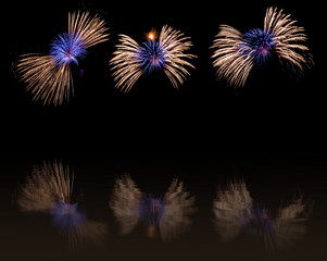 Colorful fireworks display with a reflection on the water