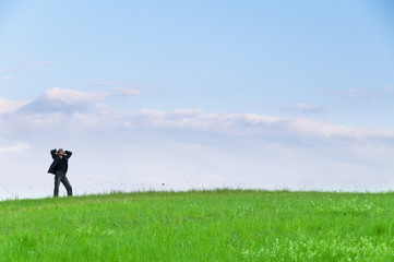 Manager steht auf der Wiese Blick in den Himmel