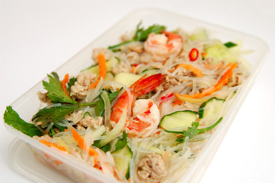 Thai spicy seafood salad in a take away box.