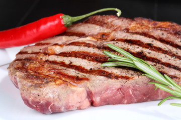 Juicy beef steak with red chili pepper and rosemary