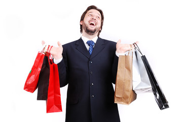 Young attractive man wearing suit and holding shopping bags