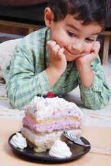Very cute kid about to eat colorful cake, isolated