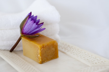 Obraz na płótnie Canvas Lotus flower, natural soap, and marble tray at a spa