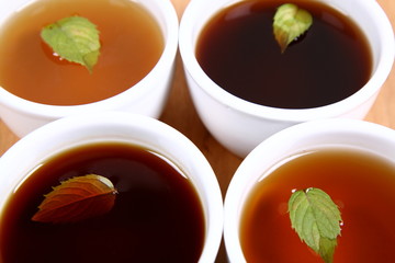 Four bowls of tea with peppermint leaves