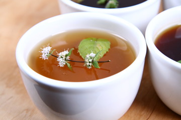 White Bowls of tea with mint leaves and twig