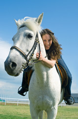 Fototapeta premium smiling girl embraces a white horse