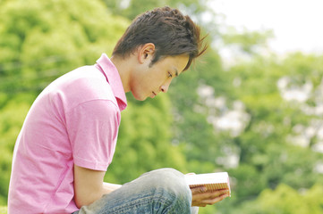 公園で本を読む男性
