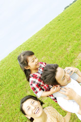 Fototapeta premium 娘を肩車する父親とそばを歩く母親