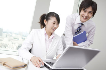 Obraz premium パソコンを囲むビジネスマンとビジネスレディ