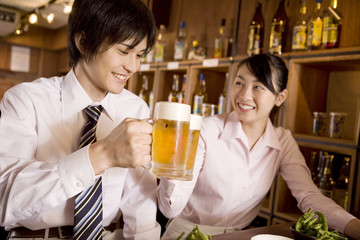 ビールで乾杯するビジネスマンとビジネスレディ