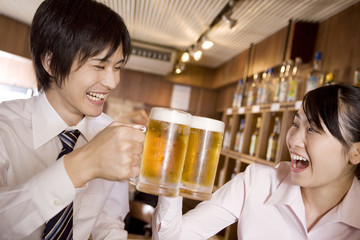 ビールで乾杯するビジネスマンとビジネスレディ