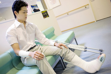 イスに座る骨折した男性患者