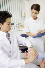 Obraz premium 男性患者を診察中の医者と看護師