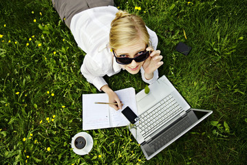 young blonde woman working outside on computer #1