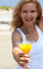 Happy young blond woman with glass of oranje juice