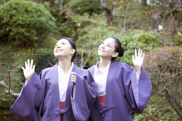 手を振る浴衣女性2人