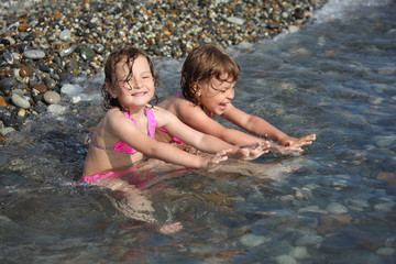 Fototapeta premium two little girls sit in sea