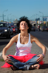 girl in pink skirt meditates on highway middle